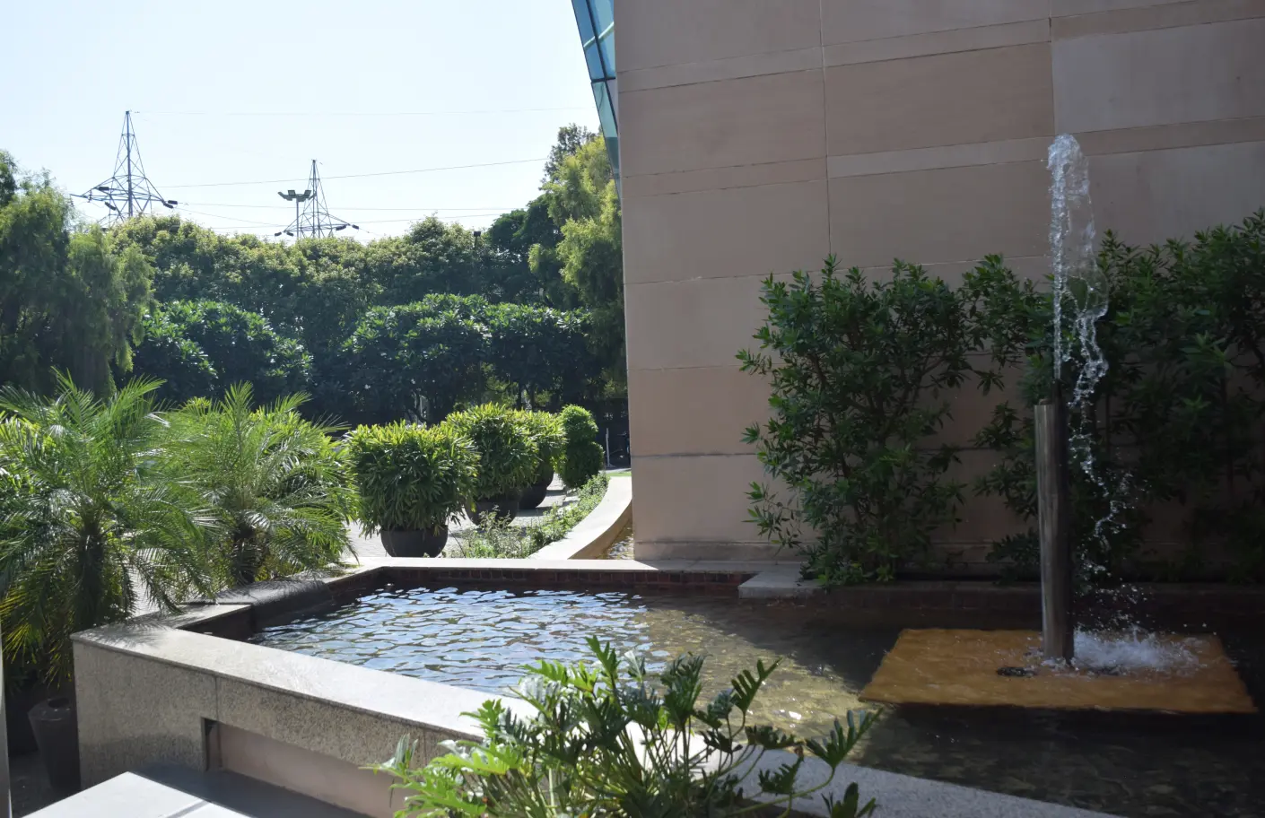 A courtyard fountain with trees & lush greenery around it captures the need of nature in the office
